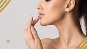 Woman touches her lower lip with her finger, profile view beauty spa by val lip filler